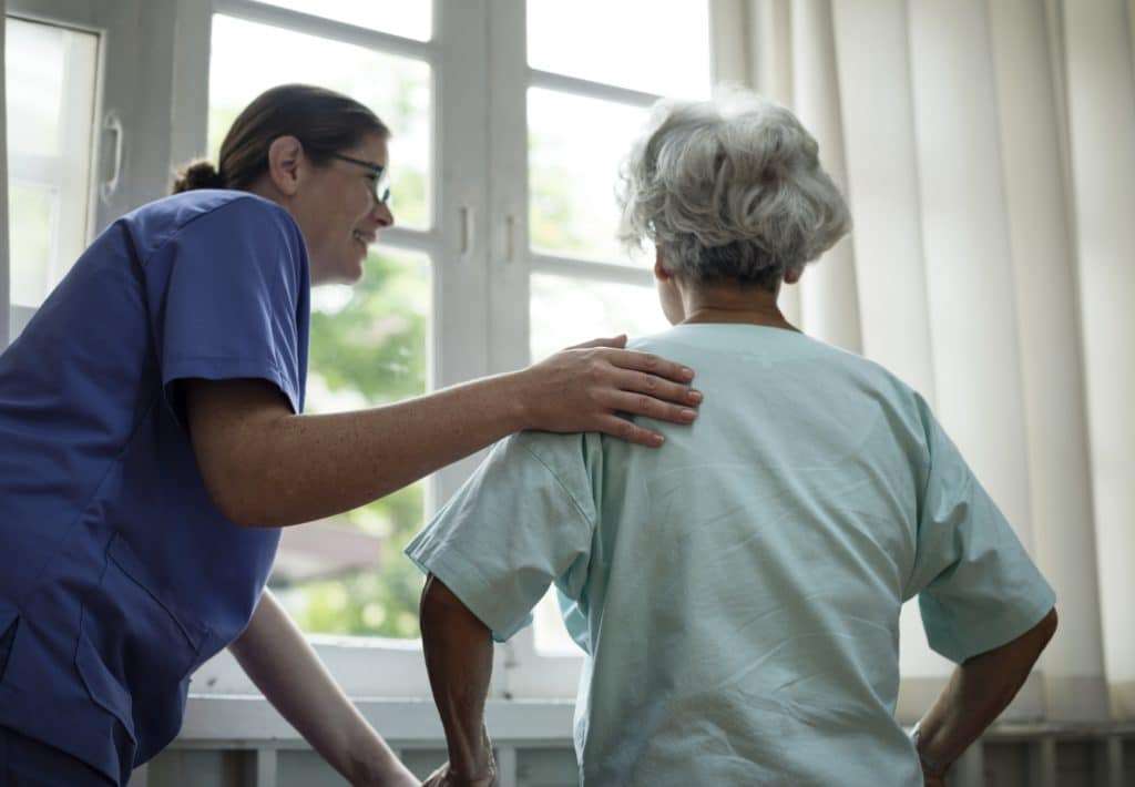 An elderly care assistant helping a resident.