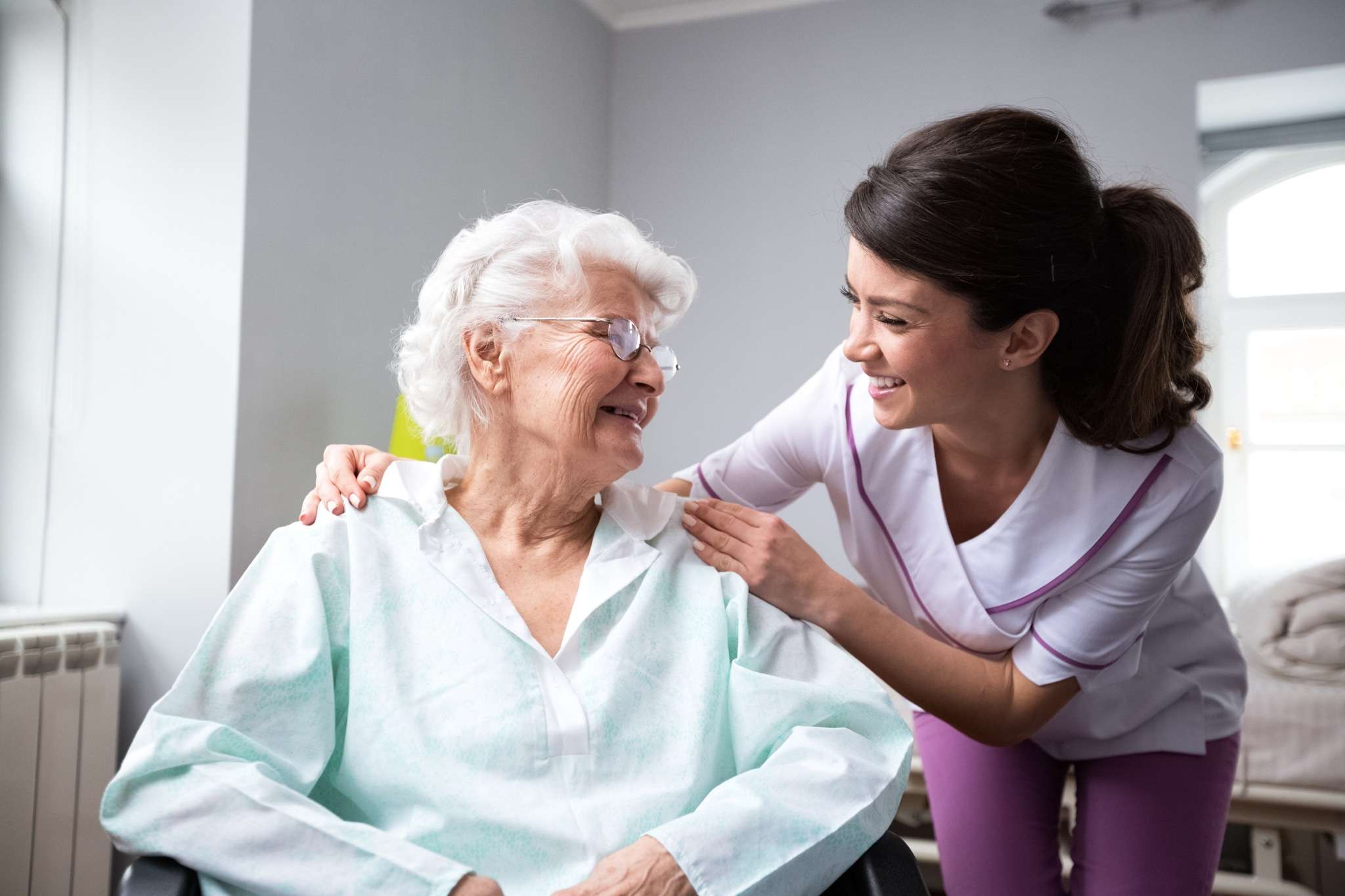 A caregiver with a smiling elderly patient.