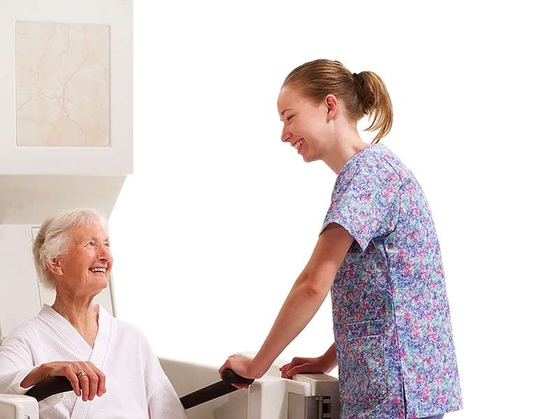 A caregiver assisting a resident into an Apollo Bath tub.